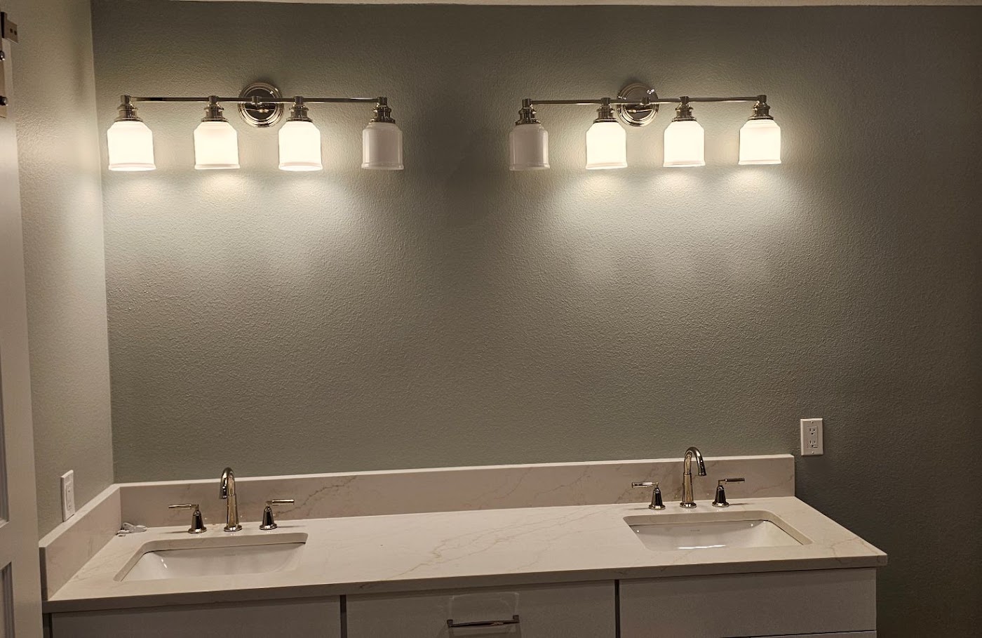 Two four-light vanity fixtures installed over a double bathroom vanity in Vancouver, WA