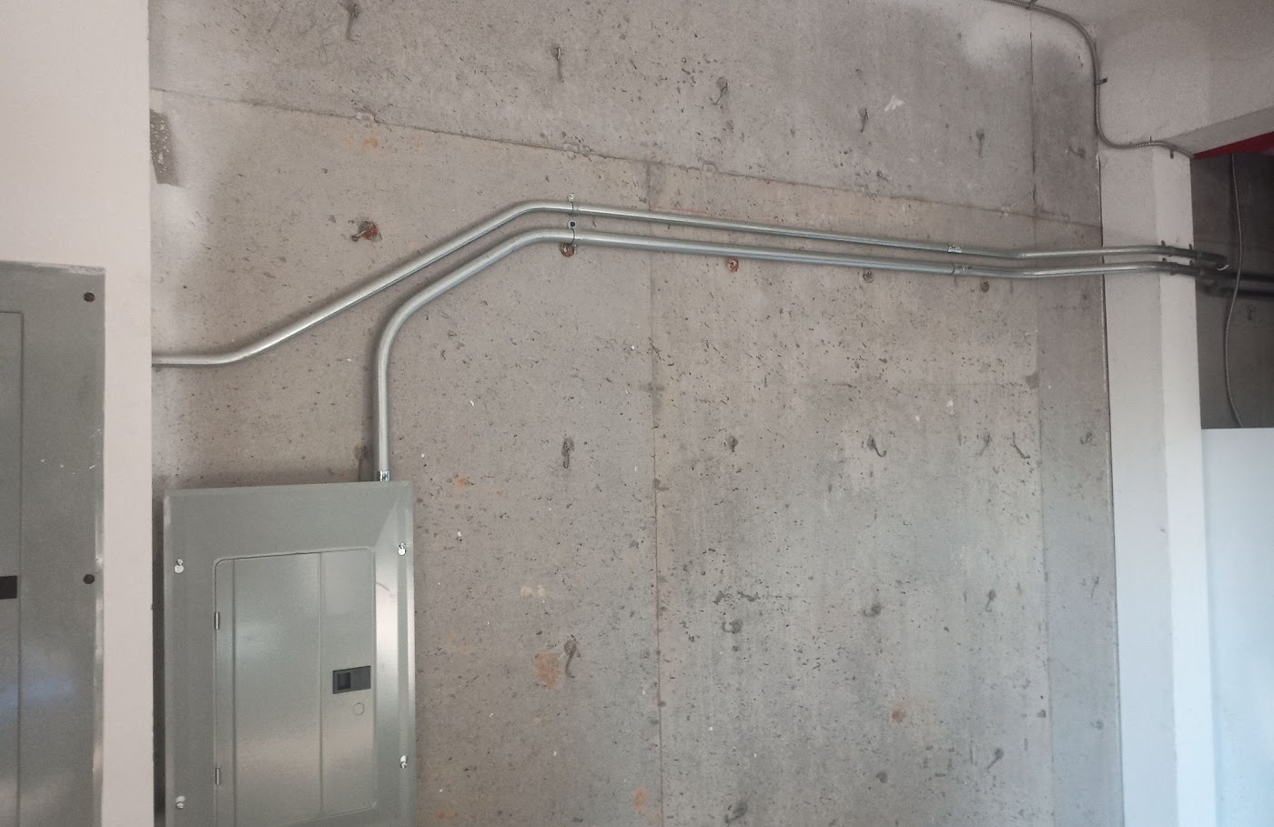 Commercial sub-panel fed by EMT conduit on a concrete wall in Clark County, WA
